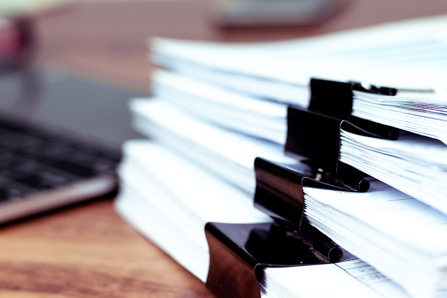 A picture of a stack of papers ready to be processed into a digital document management system.
